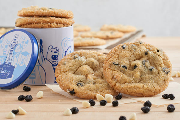 Close up of chocolate chip cookies with lion anniversary tin in the background