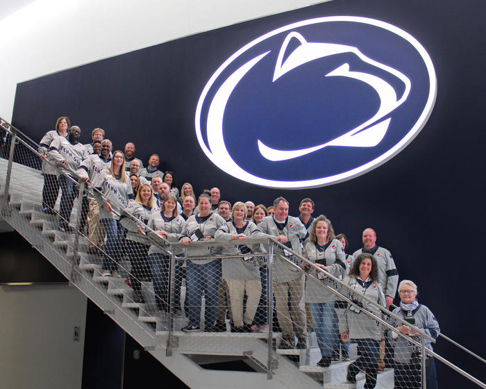 ABS staff standing on a staircase smiling at the camera